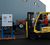 man-wearing-a-red-shirt-driving-a-yellow-forklift-that-is-holding-a-Rogers-Machinery-Engineered-Vacuum-System