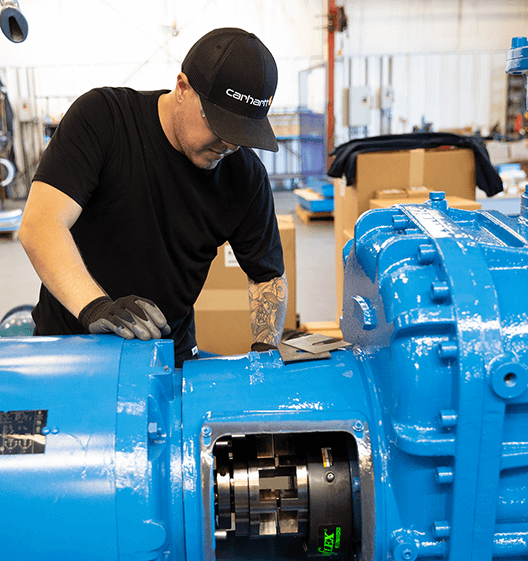 man-wearing-a-black-hat-and-shirt-while-working-on-a-durable-oil-lubricated-rotary-screw-air-compressor-in-Centralia-Washington