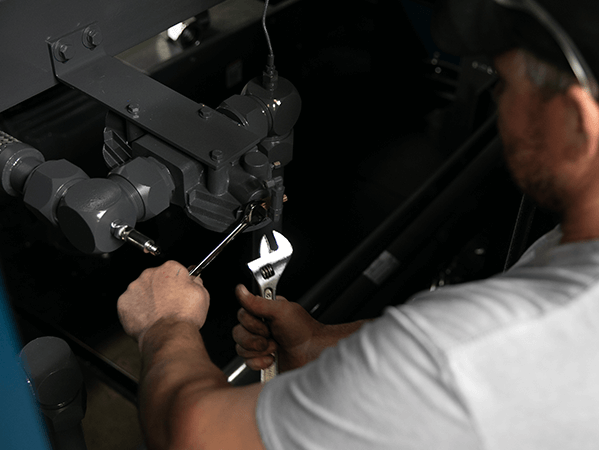 man-using-silver-wrenches-and-tools-to-build-a-Rogers-Machinery-K-Series-oil-lubricated-rotary-screw-air-compressor-in-Centralia-Washington